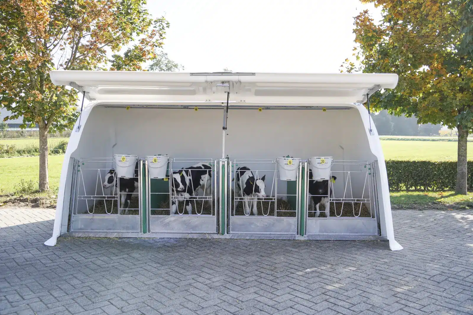 Twee CalfOTel Hybrid-kalverhokken met open front, buiten op een erf