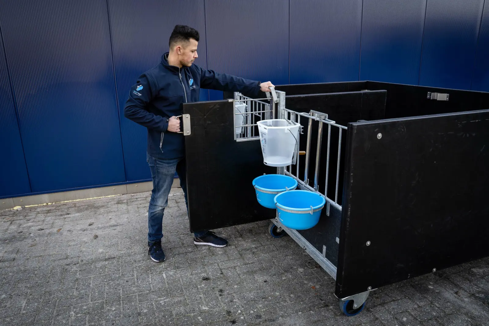 Kalverbox op wielen met emmers aan het fronthek